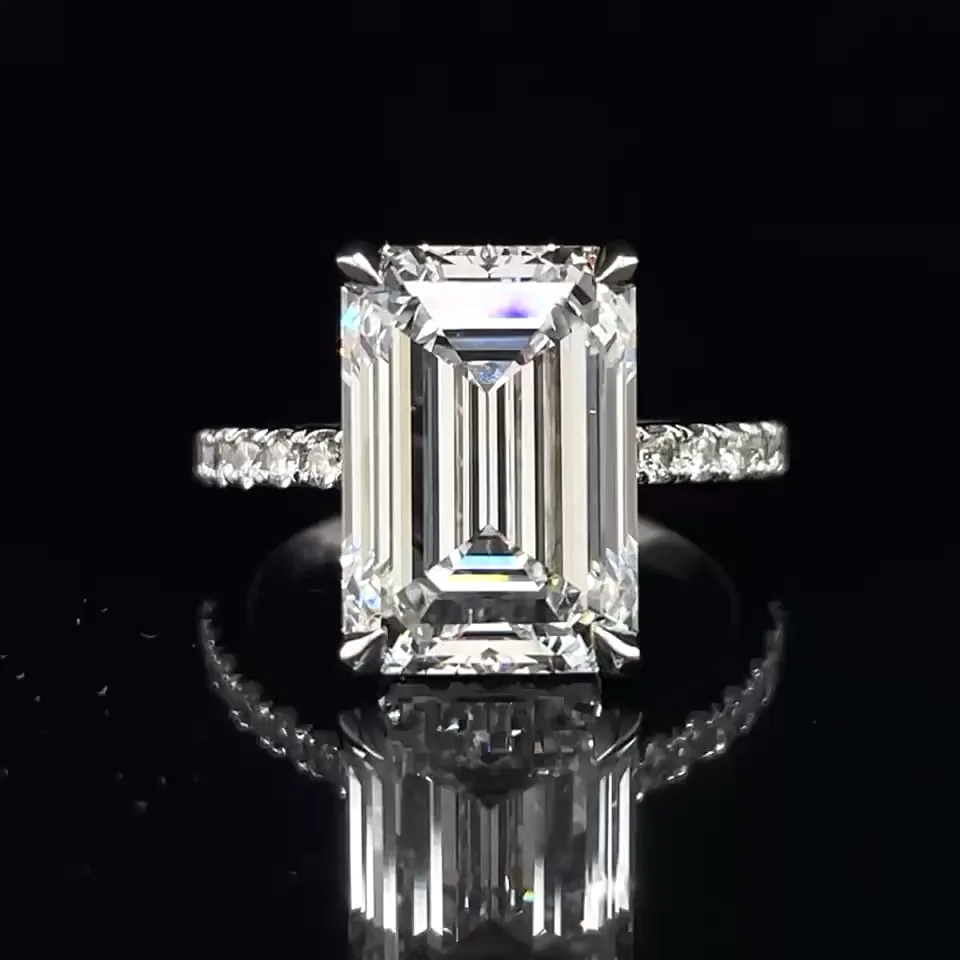 Emerald-cut diamond ring with diamonds on a black display