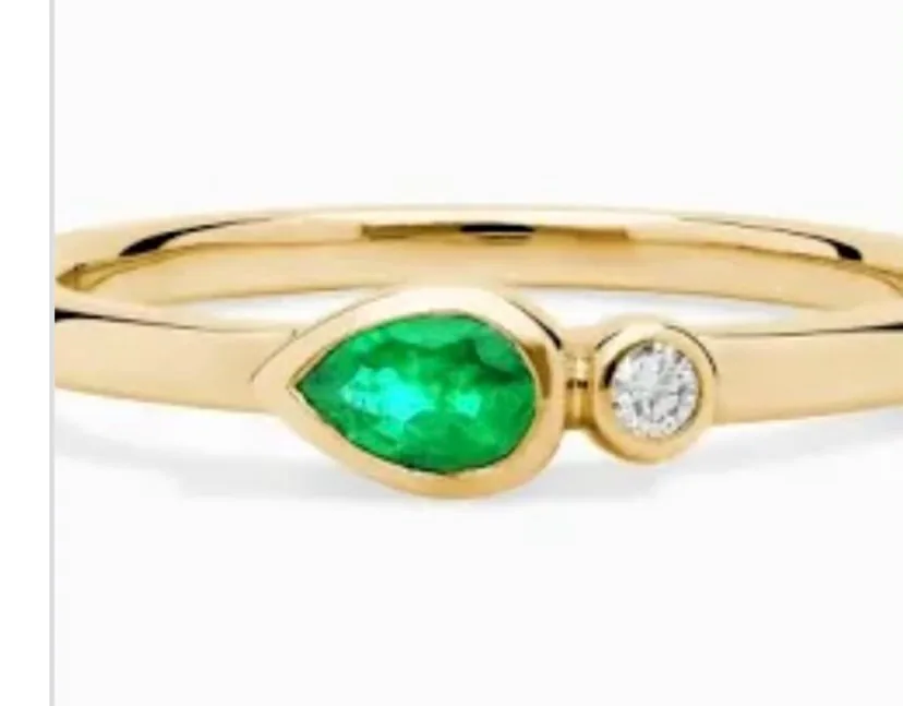 Gold ring with a vibrant emerald and diamond